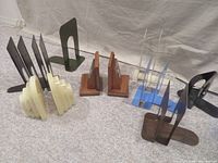 Photo showing multiple pairs of vintage bookends in different materials and styles arranged in a row