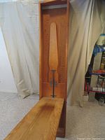 Front view of cabinet with larger ironing board folded down, showing wood grain and metal support.
