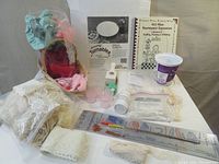 Overview photo showing turntable, lace bundles, silica gel powder container and bag, Fasturn sewing tool, decorative punches, and crafting book.