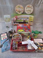 Overview of garden lot showing microgreen kit, flat hose, gardening books, seed packets, garden tool tote with small tools, and other assorted items.