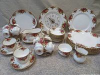 Assorted Old Country Roses bone china pieces including dinner plates, cups, saucers, nappy bowls, cream jug, sugar bowl, cake plate, gravy boat, and wall clock