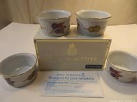 Four Royal Worcester Evesham Gold porcelain ramekins arranged around original gold presentation box with an 8 recipe leaflet in front