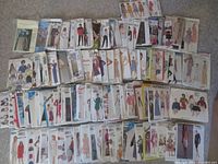 Photo showing rows of assorted vintage sewing patterns with illustrated garment options, including dresses, skirts, pants, tops, jackets.
