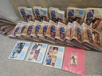 Complete set of ten instructional binders, sewing patterns in storage sleeves, empty binders, and index booklet spread out on floor, showing full collection.