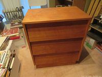 Front view of the wooden three-drawer bureau showing the smooth drawers and overall condition.