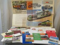 Photo showing a Brush-Sulzer Type 4 Diesel-Electric Locomotive educational poster and a spread of vintage train-related booklets and documents on a table.