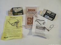Front view of two Behr spectacle loupes with original boxes, pamphlets, and product literature.