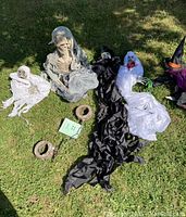 Decorations displayed on grass showing skeleton bride and groom, ghost figures, and bases