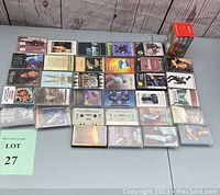 Photo showing 38 audio cassette tapes arranged on a table with visible album covers and cassette labels.