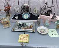 Wide view of lot showing clocks, figurines, ornaments, floral decors, vanity tray, and decorative plaque