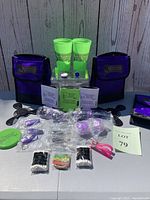 Photo of the full lot showing the insulated purple bag, neon green cups, multiple keychains, sunglasses, yo-yos, frisbee, and promotional items arranged.