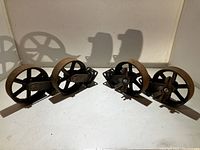 Four 9.5 inch steel casters with solid mounting brackets shown from the front on a white surface.