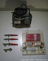 Overview photo of the air brushes, parts case, and compressor showing entire lot contents