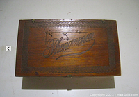 Top view of the wooden cigar box lid showing the engraved 'Phenomenon' script and decorative border.