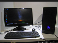 Photo of desktop computer setup showing tower, LG monitor, keyboard and mouse on white desk against a white wall