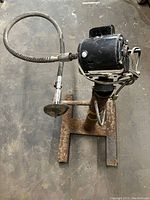 Side view of the flex shaft grinder/buffer showing motor, flexible shaft, grinding wheel, and stand