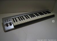 Side angled view of M-Audio Key Rig 49 MIDI controller keyboard showing keys and control wheels.