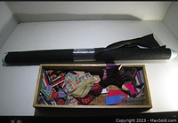 Overall lot showing roll of black faux gator leather and box of sari trims and fabric borders