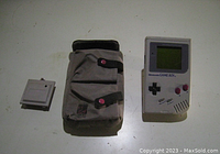 Nintendo Gameboy handheld console displayed with carrying case and link cable on white surface