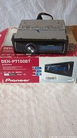 Front view of the Pioneer DEH-P7100BT CD receiver unit on the original red and white box showing the model number and basic features.