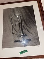 Framed black and white photographic art print featuring a trumpet on a stand, signed and numbered 11/15.