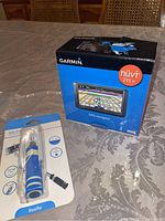 Garmin nüvi 255W GPS box and closed selfie stick packaging on a table