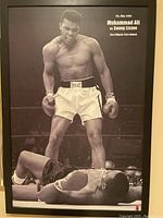 Full view of the black-and-white framed photo showing Muhammad Ali standing over Sonny Liston lying on the boxing ring floor.