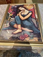 Full view of the framed print showing the seated young woman in a colorful setting.