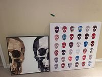 Two framed skull art pieces leaning against a wall; left has two large stylized skulls, right has 36 colorful small skulls