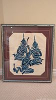 Framed vintage Thai temple charcoal rubbing showing three seated Thai musicians in traditional attire with elaborate headdresses and musical instruments.