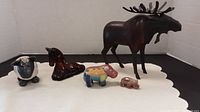 All five animal figurines displayed on white cloth background: metal moose, horse, sheep, hippopotamus, baby hippo.