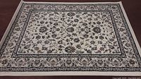 Full view of the white IKEA area rug showing the entire pattern and border.