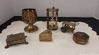 Full set of brass miniatures including goblet, sand timer, cheese wedge box, wheelbarrow, and rectangular box.