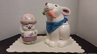Both chick and rabbit cookie jars on display mat, showing size and overall look