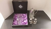 Glass pitcher in black Edinburgh International box with purple satin lining and other glass pieces beside it
