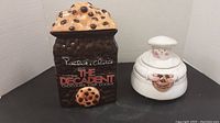 Front view of large brown Presidents Choice cookie jar with cookie chip lid and white baker cookie jar shaped like a chef