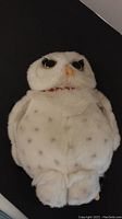Front view of the white spotted Hedwig owl plush showing facial details and body
