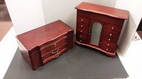 Two wooden jewelry boxes shown side by side on a flat surface with a gray backdrop.