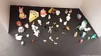 Overview of multiple miniature animal figurines arranged on a black surface