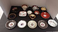 Top view of assorted cups and saucers showing varied patterns, colors, and designs