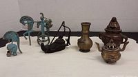 Photo showing the Roman chariot figurines, horse, and helmet brass items with greenish patina.
