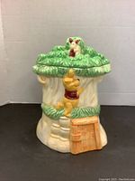 Front view showing Winnie the Pooh climbing tree house with Roo at the top and the wooden door propped open.