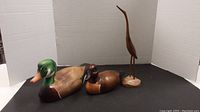 Photo showing all three wood bird figurines together: two ducks and one heron