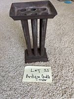 Front view of the antique candle mold showing six candle cavities and four vertical supports.
