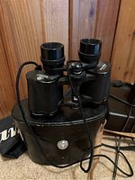 Front view of Pentax binoculars resting on the carrying case