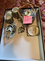 Overview showing teapot with bamboo handle, cups, small pitcher, and decorative plates on white tray.