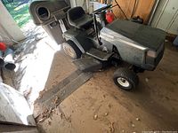 Front-side view of the dark green Craftsman riding mower with attached grass catcher