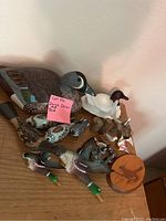 Overview photo showing all duck and bird decor items grouped together on a wooden surface, including carved wooden ducks and smaller bird figurines with a wooden engraved piece.