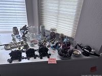 Overview of all figurines and decorative items placed on window ledge and shelf, showing variety and quantity.