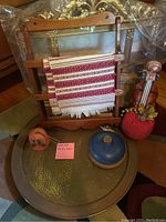 Photo showing five decor items including fabric on wooden frame, metallic tray, fabric pumpkin, ceramic lidded container, and wooden violin scroll decor.